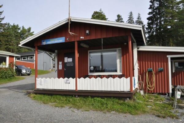 Liten röd stuga med vitt staket
