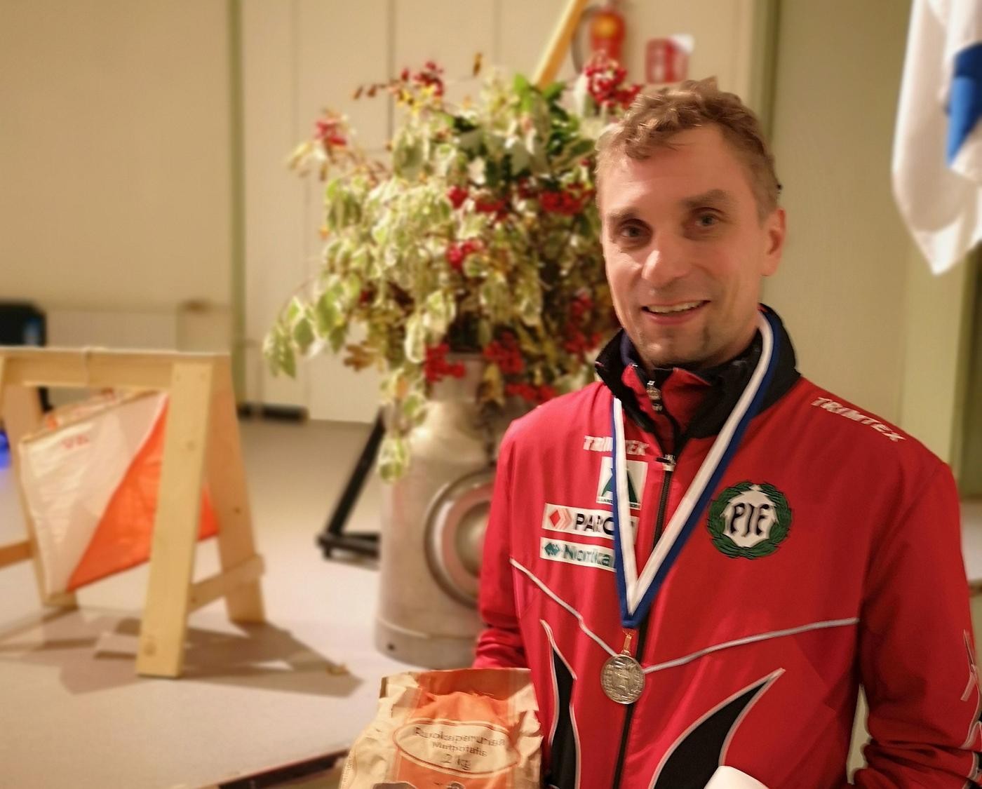 en man i idrottsoverall med en medalj