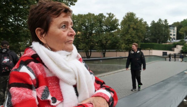 Porträtt av Johanna Ringbom som står med armarna lutade mot räcket på Biblioteksbron. I bakgrunden syns bron och en man som går på den. Ringbom blickar fram över broräcket.