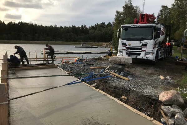 män jobbar med gjutning av en brygga. lastbil syns.