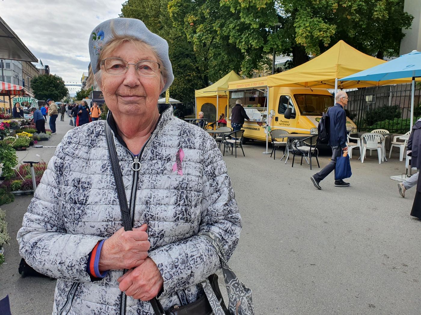 äldre kvinna med basker är på torget på uppköp