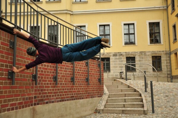 ung man gör en avancerad parkour-övning mot en vägg