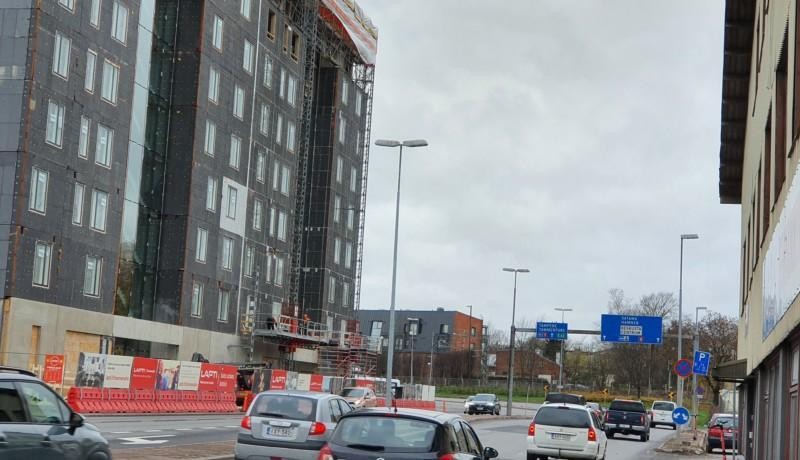 husbygge vid motorväg, bilar närmast kameran