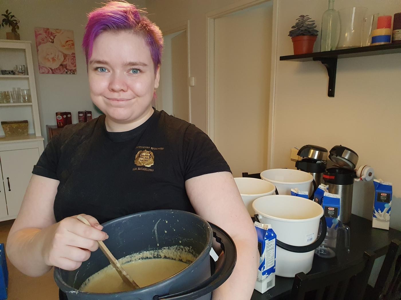 En ung kvinna med ett ämbar plättsmet i famnen.