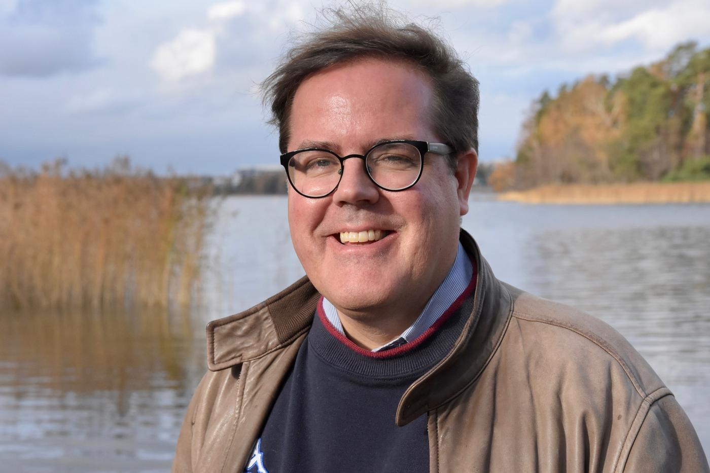 En man med sjö eller hav i bakgrunden.