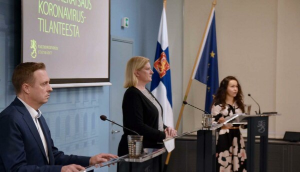 Man och två kvinnor med mikrofoner på presskonferens