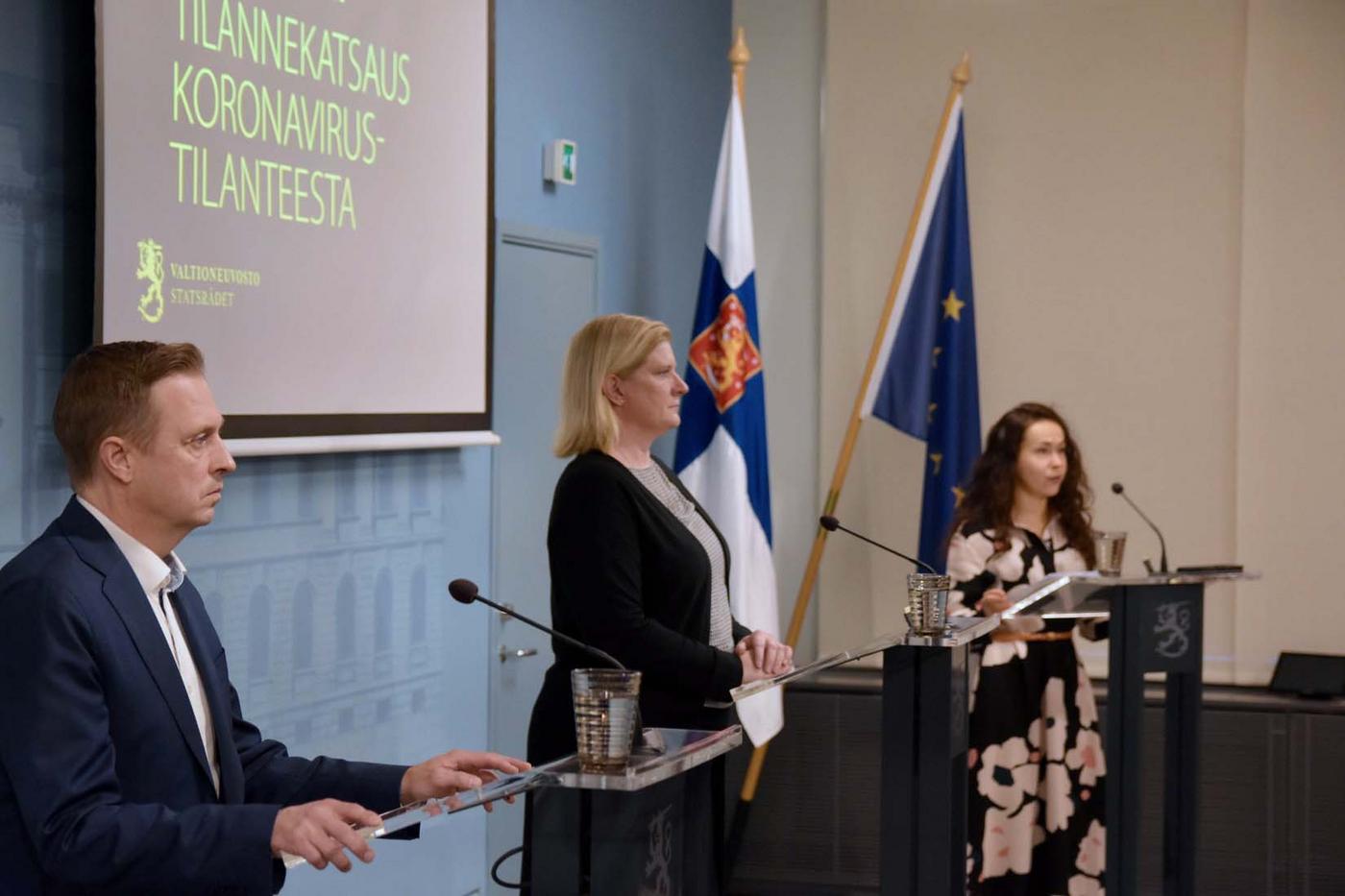 Man och två kvinnor med mikrofoner på presskonferens