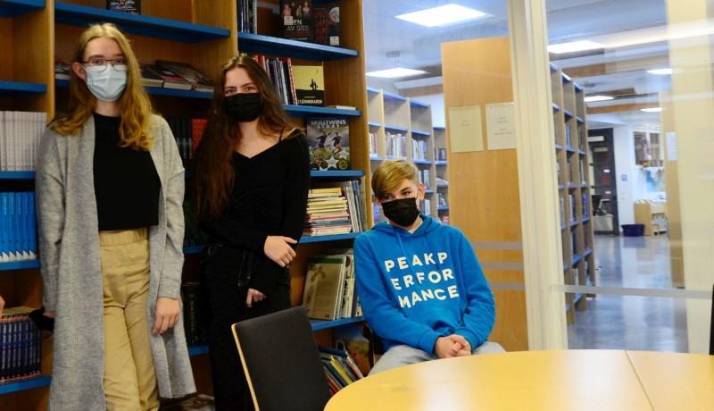 tre elever i ett bibliotek