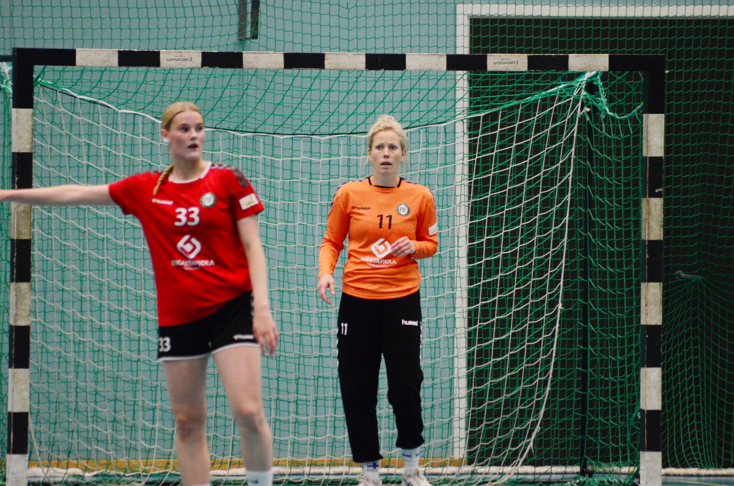 En handbollsmålvakt i orange tröja