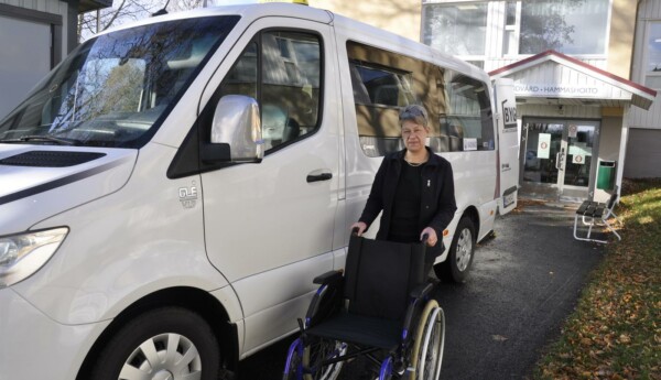 Dam med rullstol vid taxibil