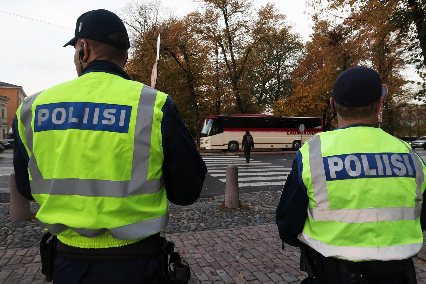 Ryggen av två poliser med neongulavästar.