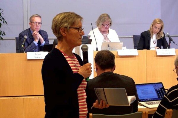 en kvinna håller i en mikrofon i en sal