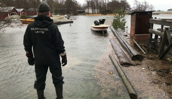 Sjöräddare står vid översvämmad strand