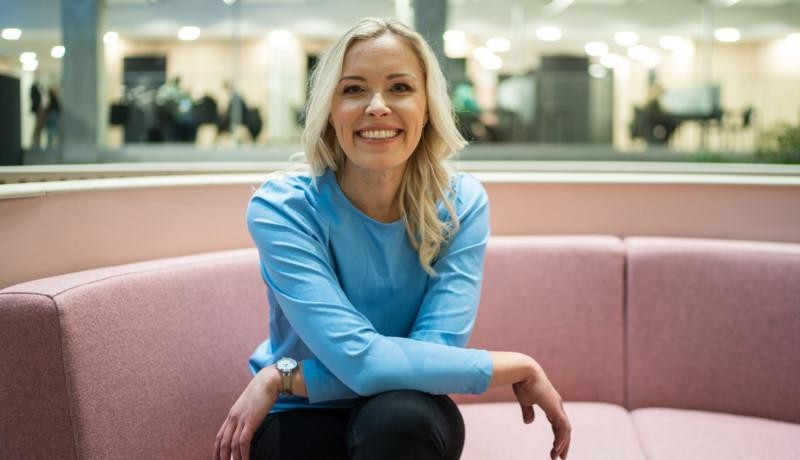 kvinna sitter ledigt och glatt i en soffa