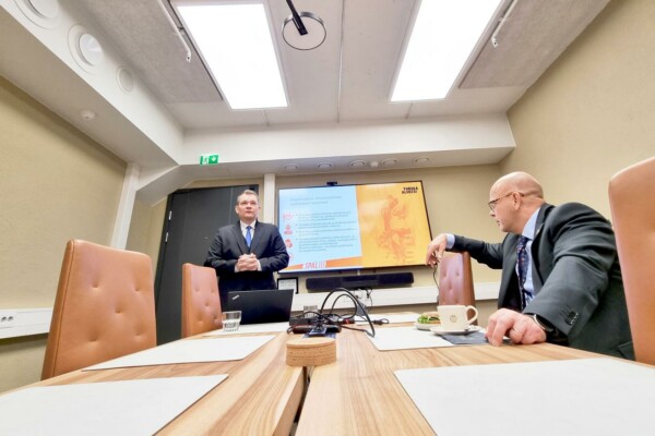Två män i kostym håller en presentation