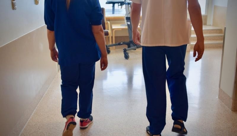 Två personer i en sjukhuskorridor.