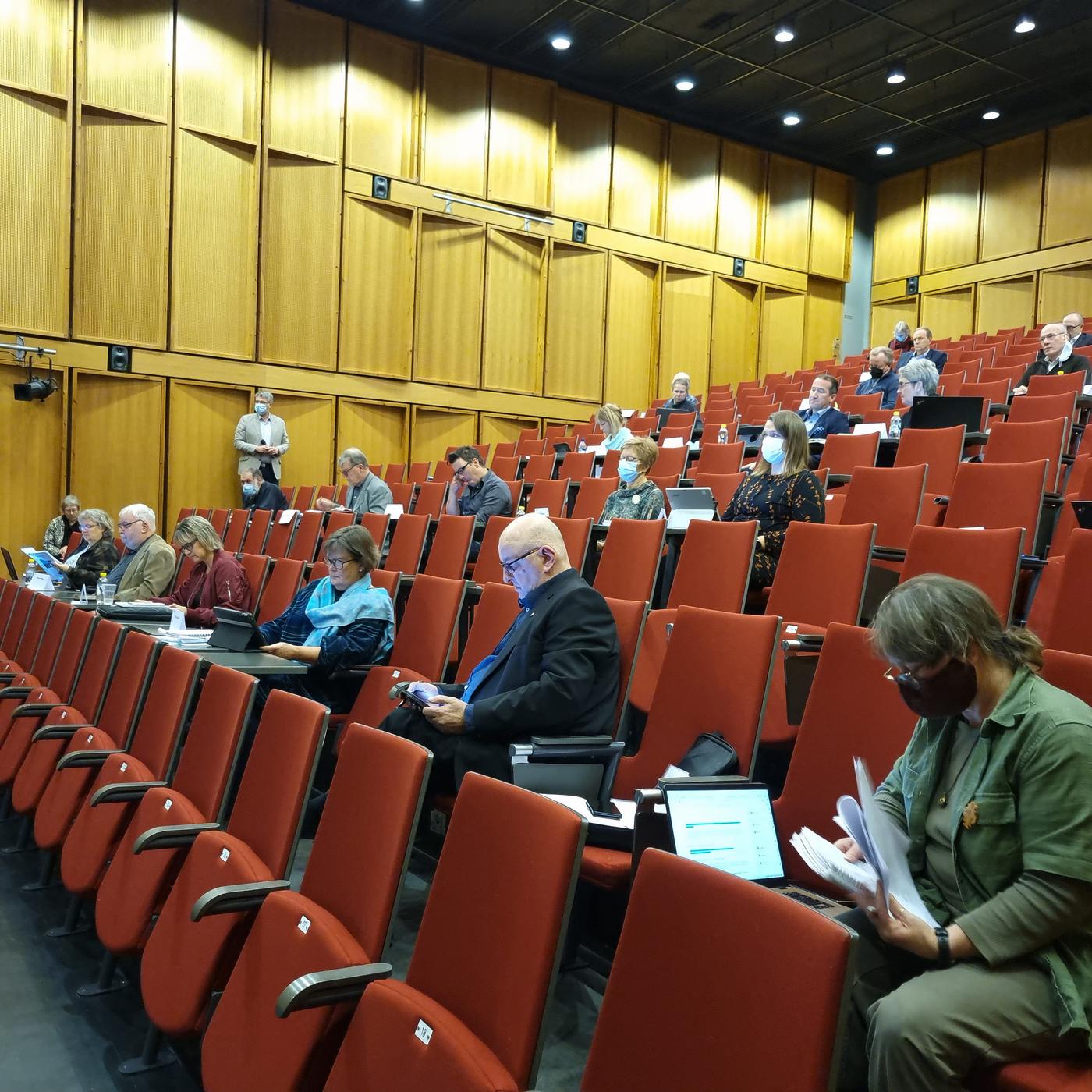 fullmäktigemöte i auditorium. Glest mellan deltagarna