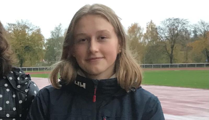 en kvinna vid en friidrottsplan