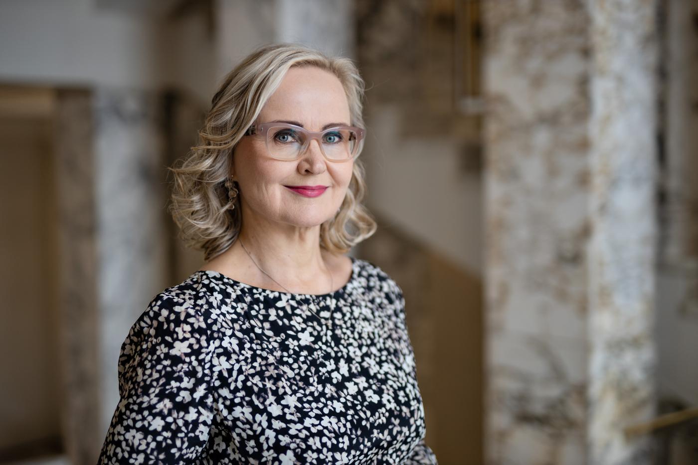 en kvinna med glasögon och en småblommig blus