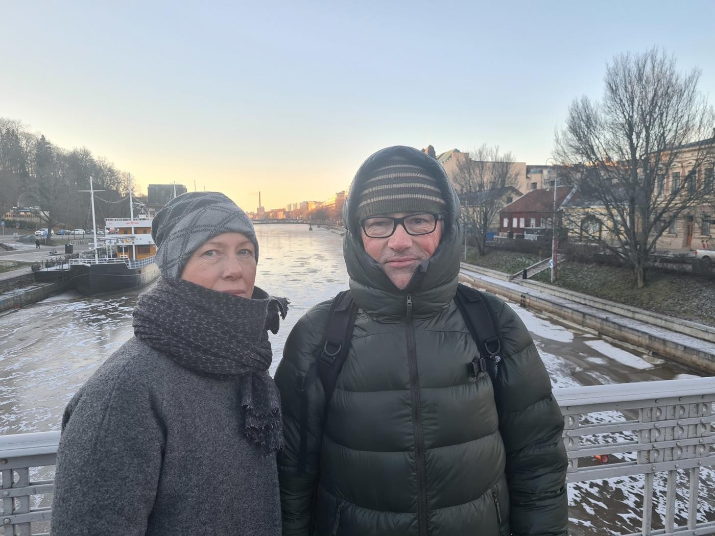 En kvinna och en man står på en bro