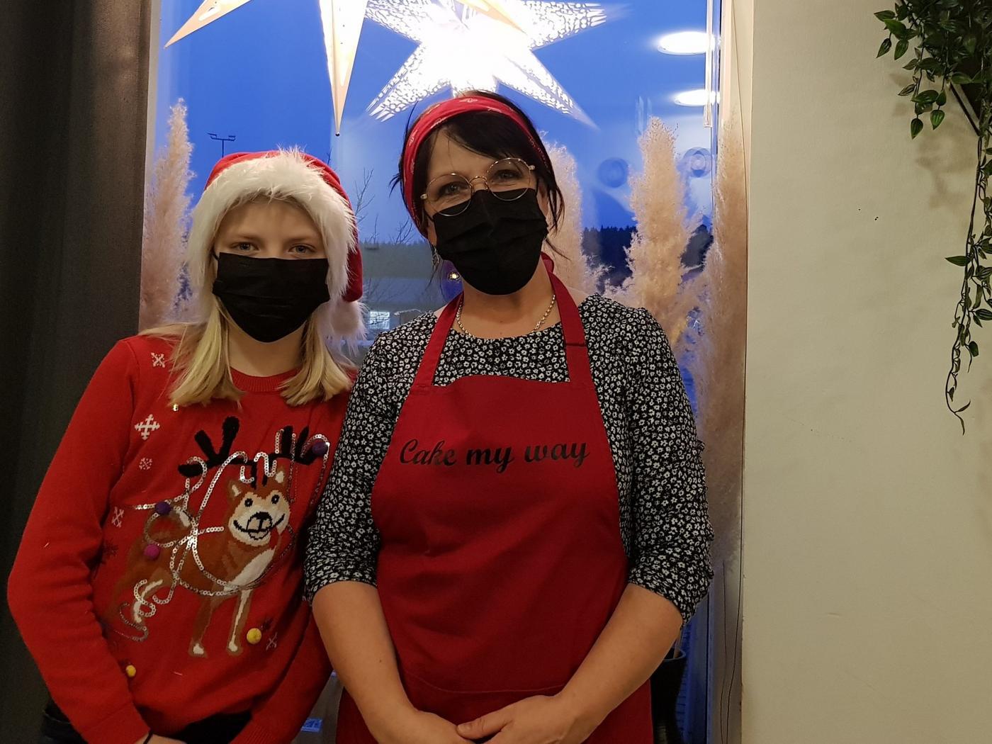 Två personer i ett fönster med julstjärna.