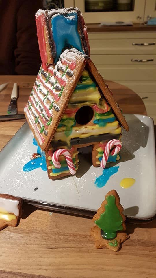 ett pepparkakshus med en liten grön gran i förgrunden