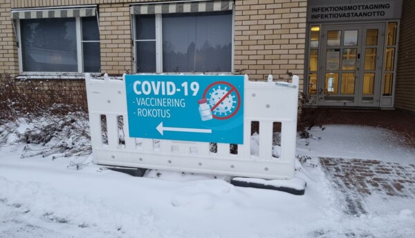 blå skylt med texten covid 19 och vaccinering