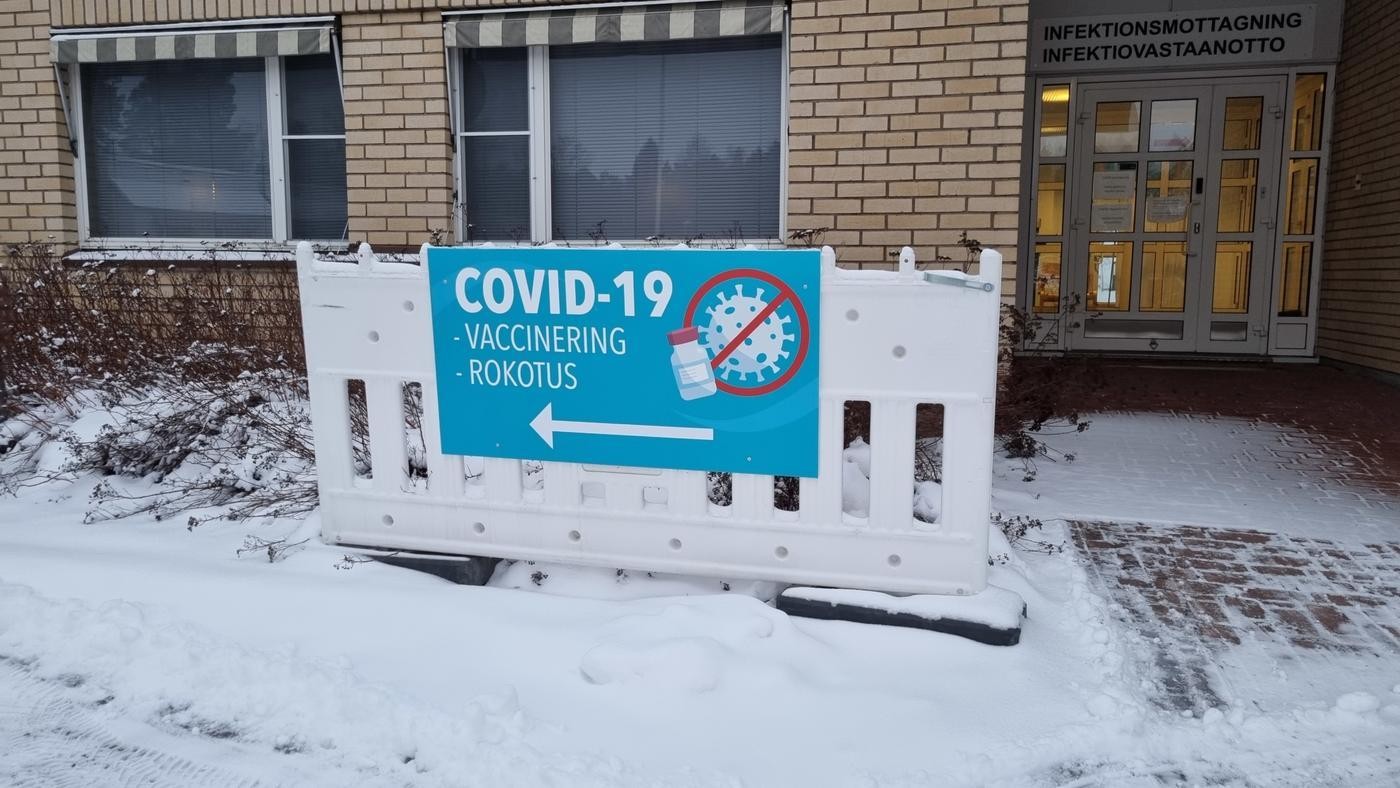 blå skylt med texten covid 19 och vaccinering