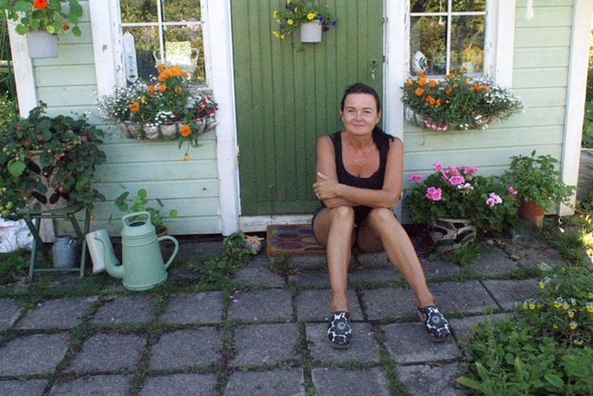 Kvinna sitter på stugtrappa