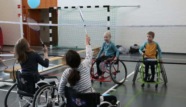 barn i rullstol som spelar med bollar