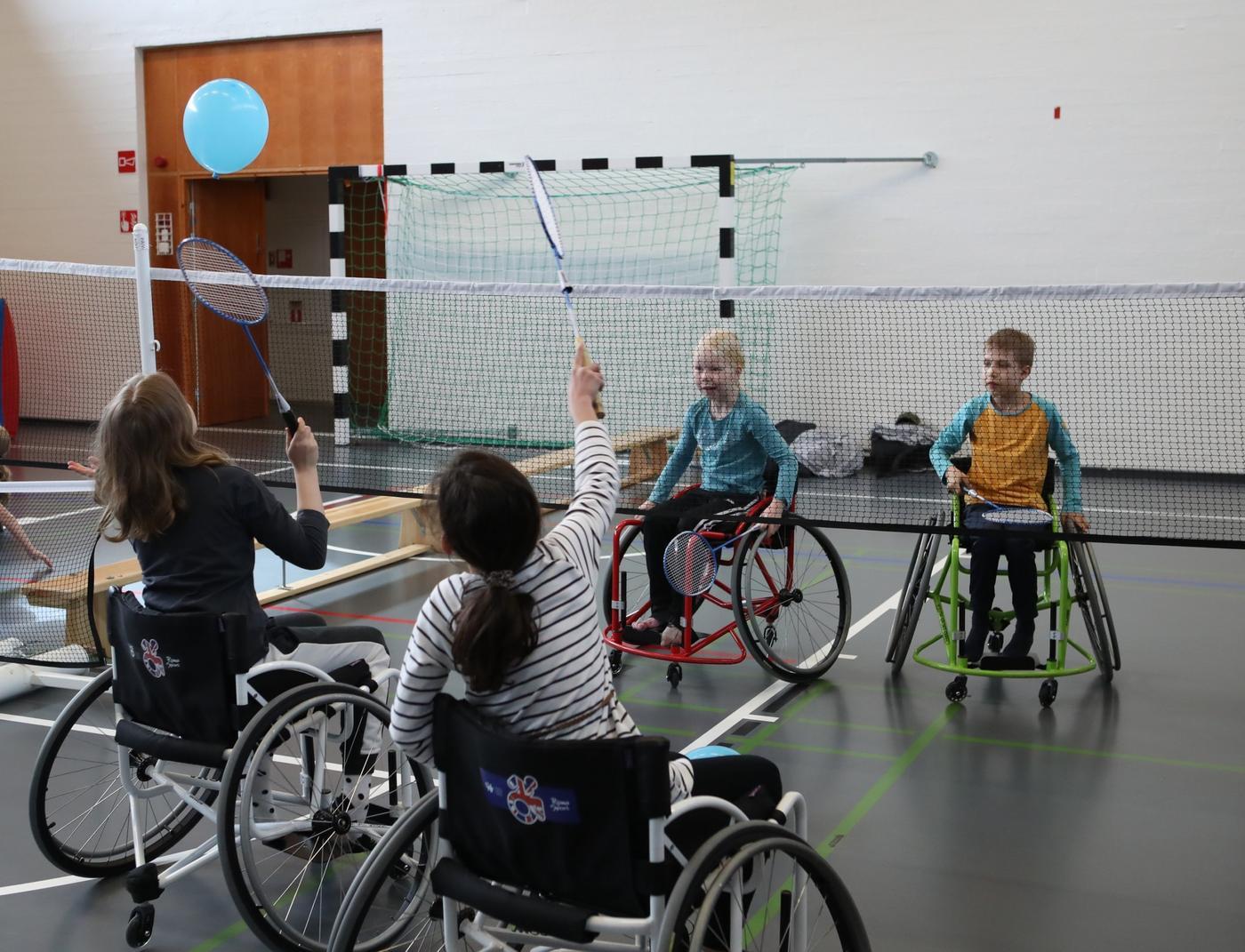 barn i rullstol som spelar med bollar