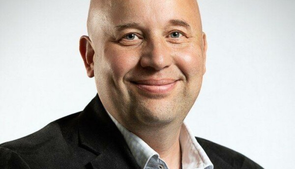 En medelåders man, skallig och leende