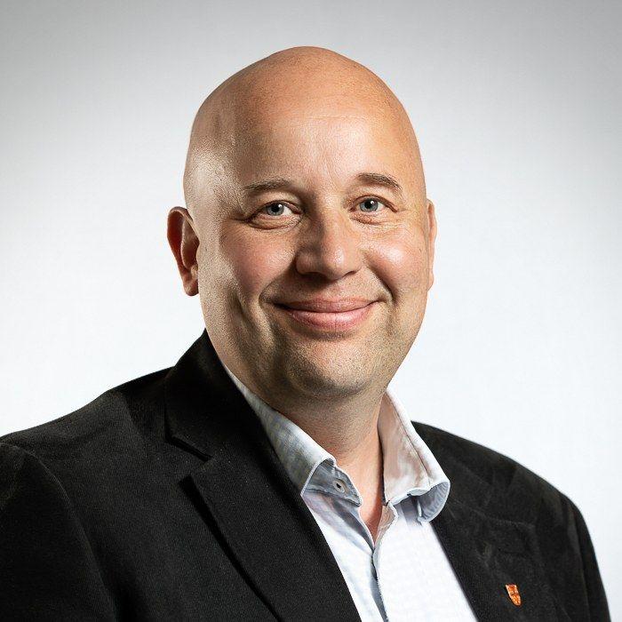 En medelåders man, skallig och leende