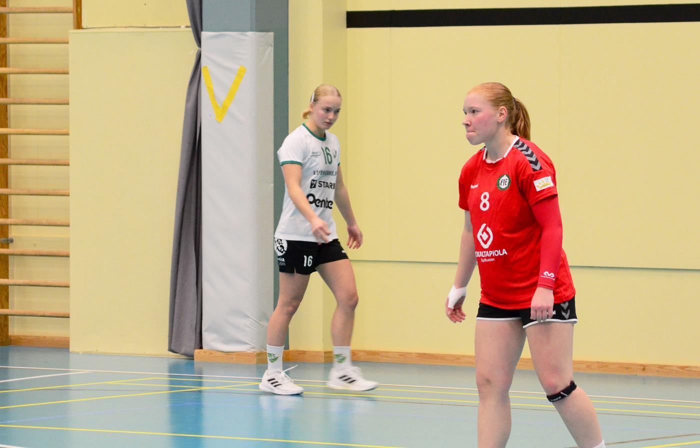 en rödklädd och en vitklädd handbollsspelare