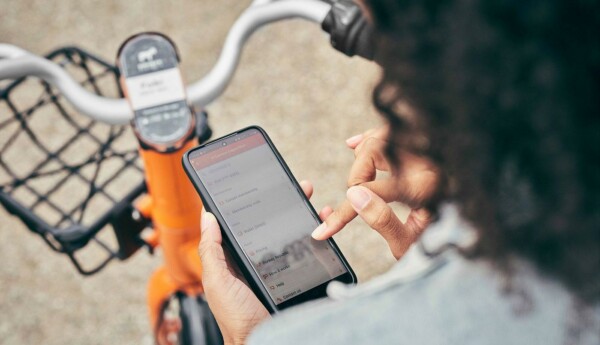 Person med cykel surfar på mobiltelefon