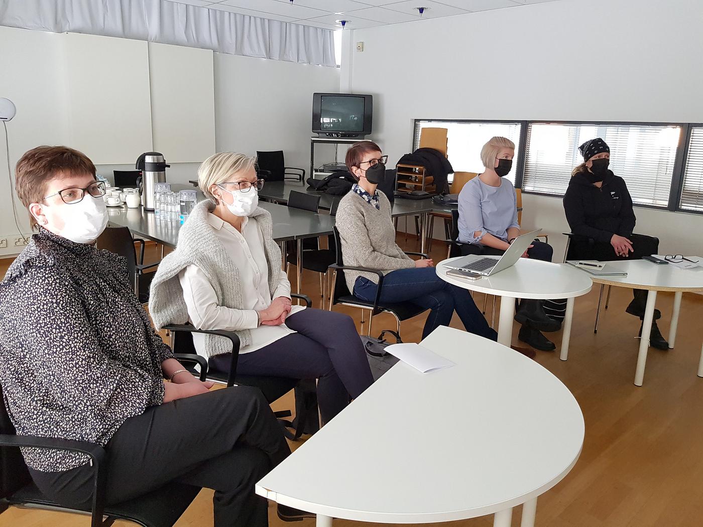 Fyra kvinnor sitter på rad - deltar i ett videomöte