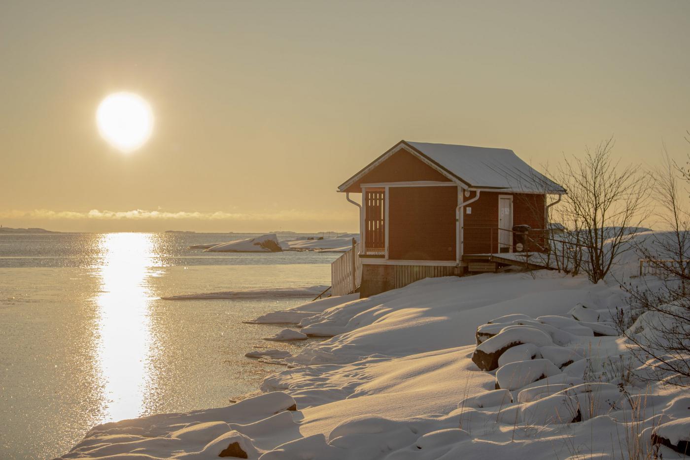 litet badhus vid hav i vintermiljö