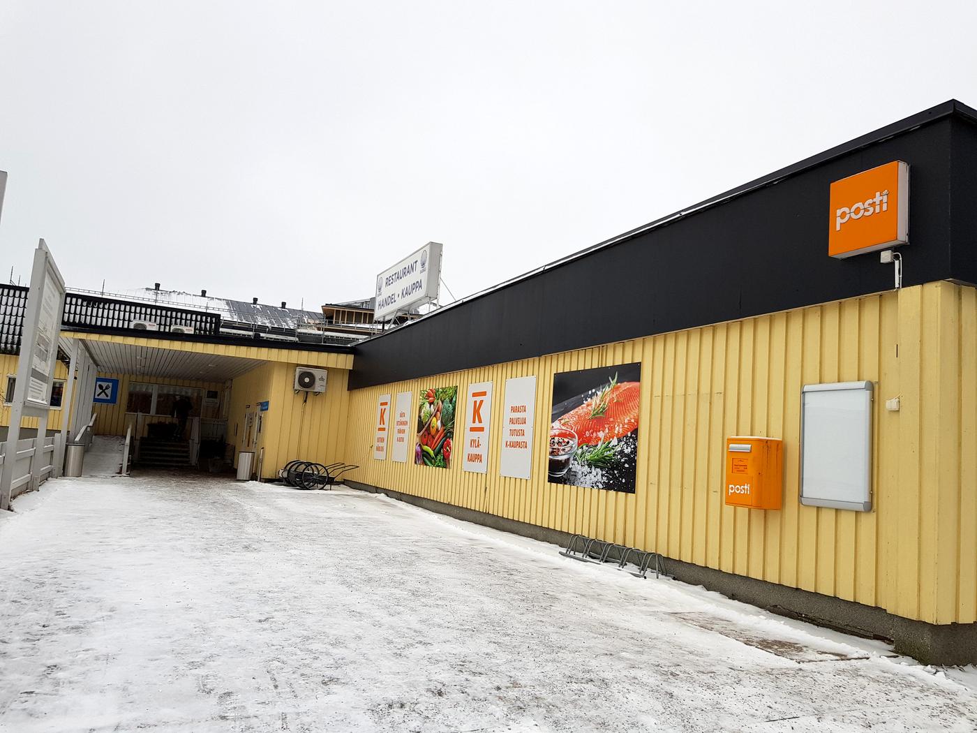 bybutik och ingång till restaurang. Gul låg träbyggnad.