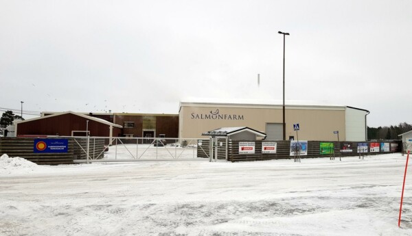 Fabrikshall med texten Salmonfarm innanför staket