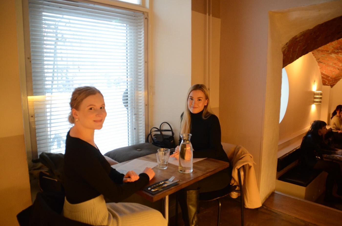 Två kvinnor sitter vid ett bord i en restaurang.