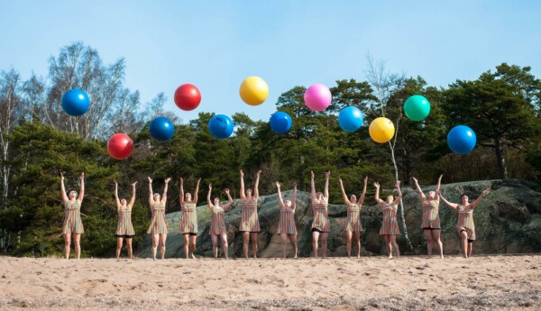 Människor med bollar på en strand.