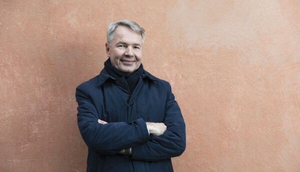 en man i en jacka framför en vägg