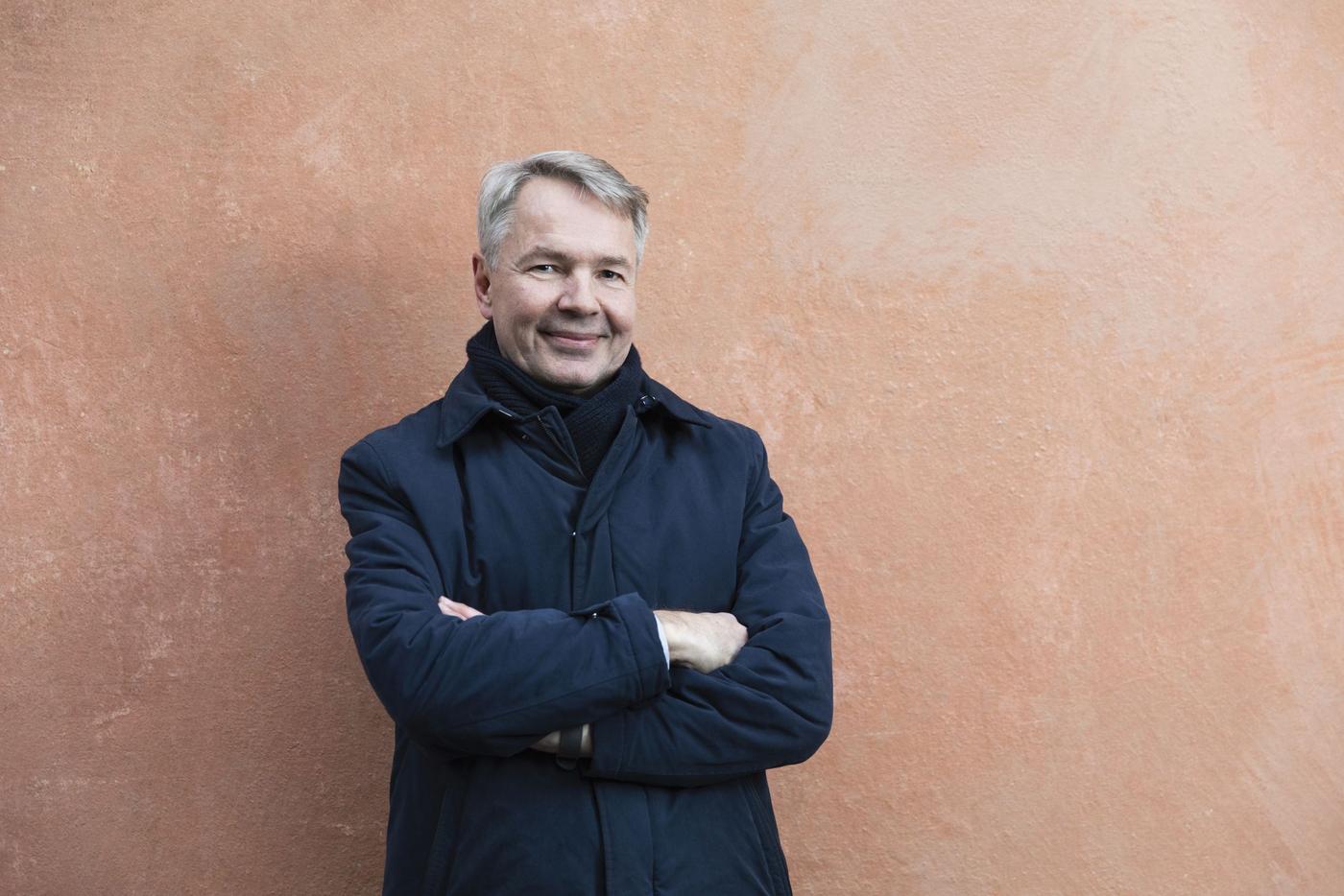 en man i en jacka framför en vägg