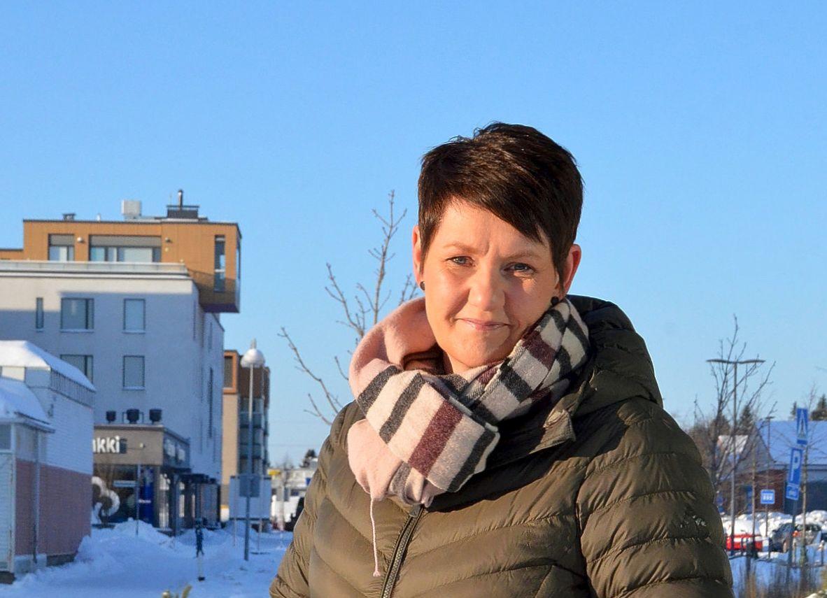 Kvinna i vinterjacka utomhus i soligt väder