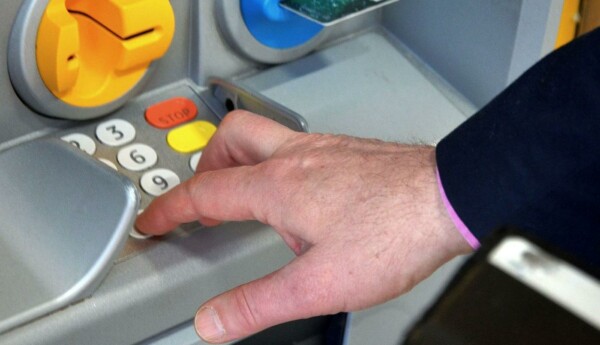 En hand på en bankomats knappsats
