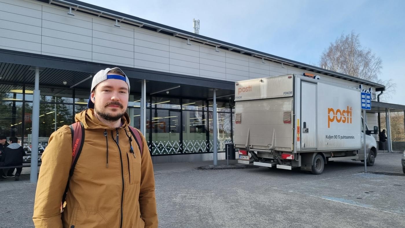 ung man utanför affär, postbil till höger