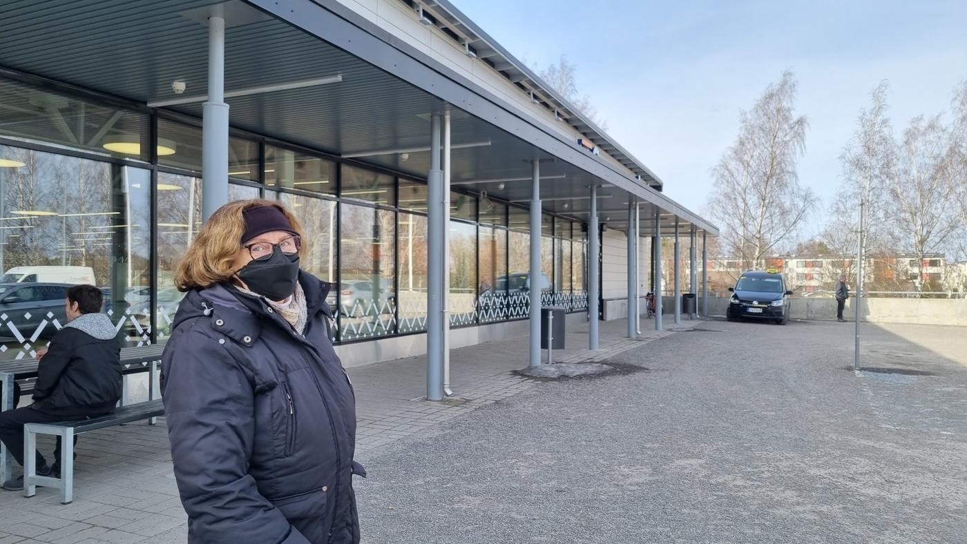 kvinna med svart munskydd utanför affär