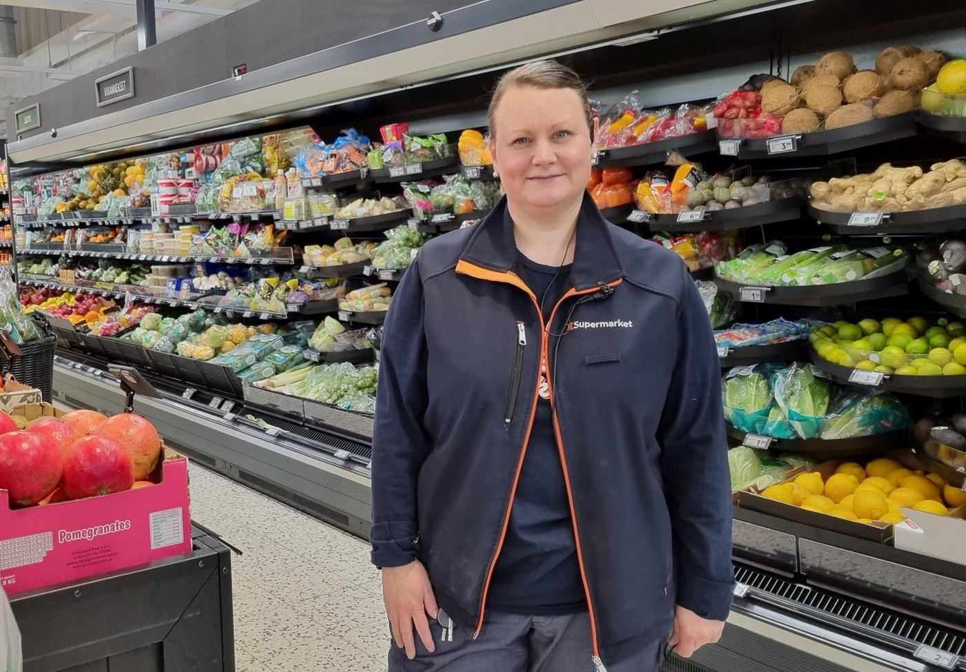 Kvinnlig köpman framför fruktdisk