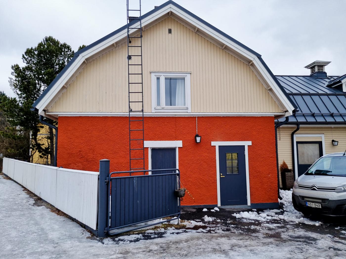 Ett litet hus i gult och rött