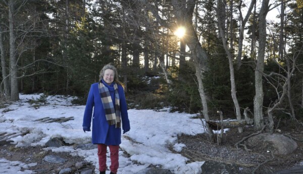 dam på en strand vid ett skogsområde